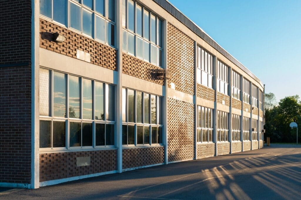 School building and schoolyard in the evening looking somber representing the importance of adressing sexual abuse in schools.