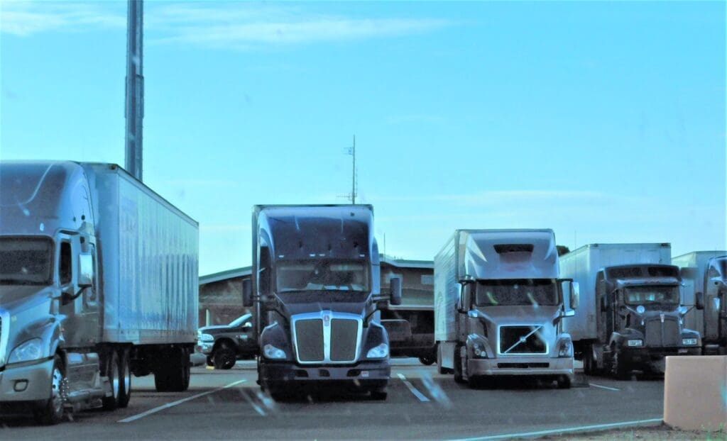 line of commercial trucks parked at a trucking school, representing the industry where safety measures against sexual abuse need to be strengthened