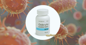 A bottle of Oxbryta medication next to a medical stethoscope, symbolizing the 2024 Pfizer recall and sickle cell patient safety concerns.